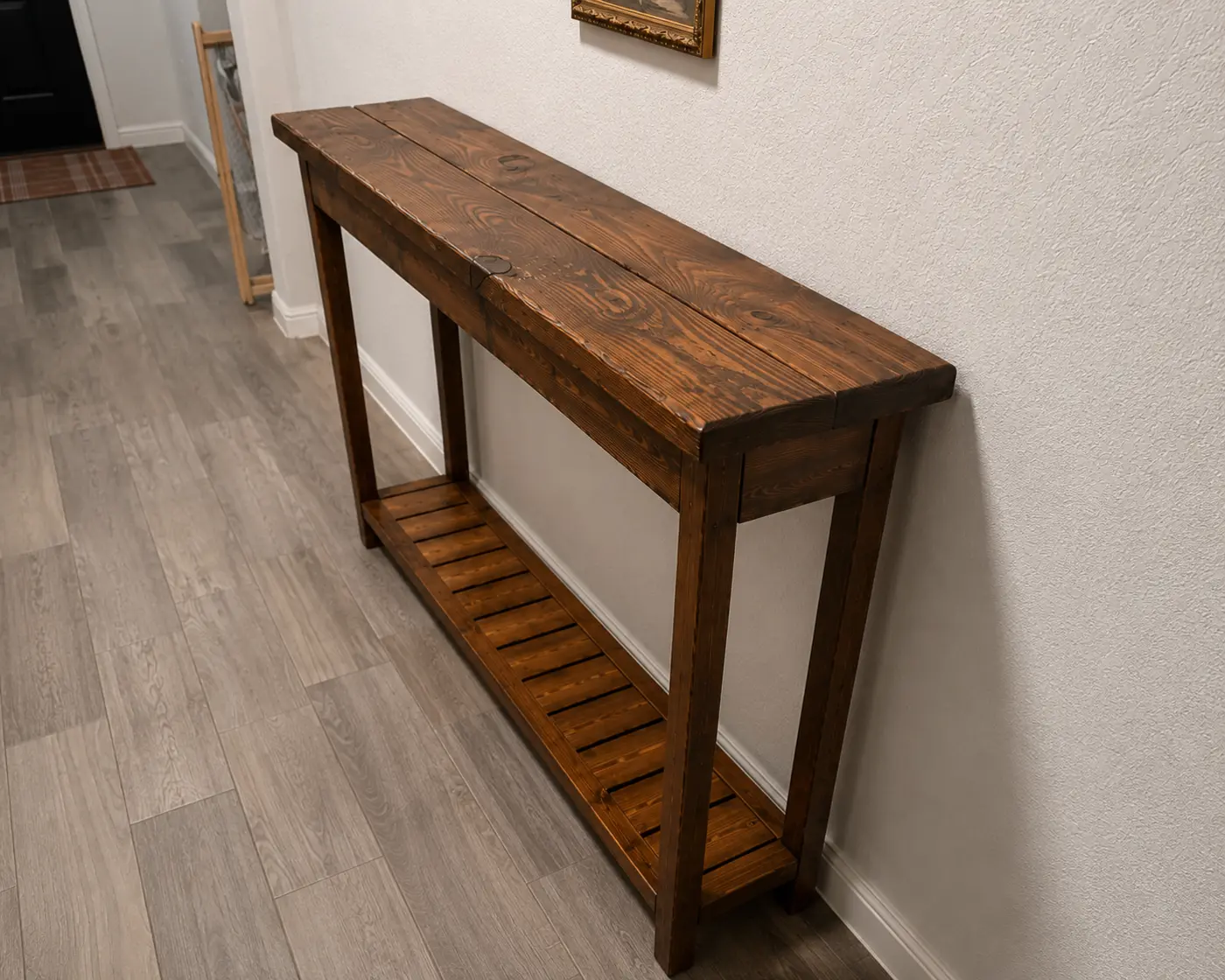 Slim rustic console table shown against a hallway wall